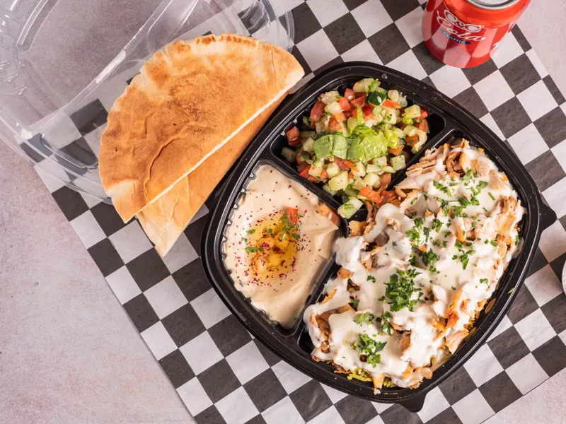 Chicken shawarma plate with rice, salad, hummus and pita